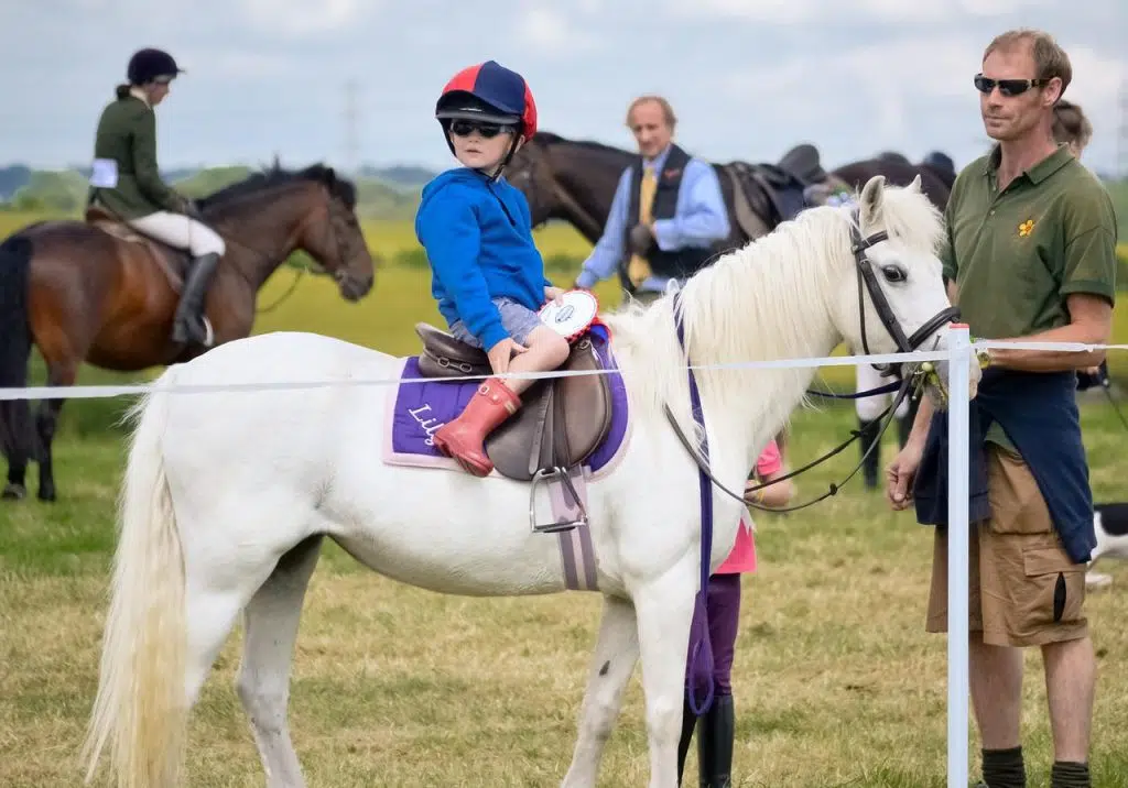 un petit garçon en tenue d'équitation sur son poney